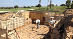 workers standing in new pool installation with wire braces to form the shell of the pool before the concrete pour stage