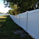 white privacy vinyl fence lining property near lakeshore