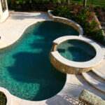built in pool with rounded border and integrated circular hottub with waterfall into pool